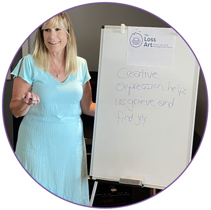 Creative Grief Coach Julie Maltby is at a white board with these words on the board: Creative expression helps us grieve and find joy.