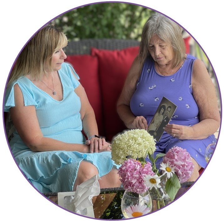 A woman shares a photo of loved ones with Creative Grief Coach Julie Maltby on The Loss Art patio.